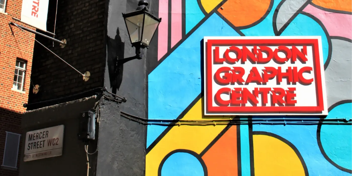 London Graphic Centre Logo. Exterior facade with colorful mural and sign “LONDON GRAPHIC CENTRE”.